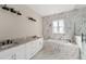 Elegant bathroom with double vanity, soaking tub, and marble tile at 5018 Elm Leaf Dr, Brooksville, FL 34601