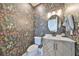 Charming powder room with floral wallpaper, a round mirror, and a light-colored vanity at 4334 Sanddollar Ct, New Port Richey, FL 34652