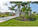 Two-story house with gray siding, stone accents, and a two-car garage; lush landscaping with palm trees at 4334 Sanddollar Ct, New Port Richey, FL 34652