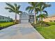 Two-story house with gray siding, stone accents, and a two-car garage,palm trees and landscaping at 4334 Sanddollar Ct, New Port Richey, FL 34652