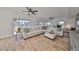 L shaped living room with hardwood floors, white sectional sofa and access to a deck and patio at 4334 Sanddollar Ct, New Port Richey, FL 34652