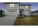 Two story house with beige siding and two-car garage at 12733 Wanderlust Pl, Parrish, FL 34219