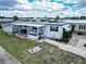 Charming mobile home featuring a covered porch, green trim, and tidy landscaping at 107 E Saint Johns Way, Apollo Beach, FL 33572