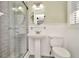 Updated bathroom with pedestal sink, walk-in shower, and grey tile at 6921 Onyx N Dr, St Petersburg, FL 33702