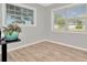 Bright bedroom with neutral walls, wood-look floors, and large windows at 6921 Onyx N Dr, St Petersburg, FL 33702