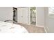 Bedroom with flamingo bedding, en-suite bathroom, and grey wood-look flooring at 6921 Onyx N Dr, St Petersburg, FL 33702