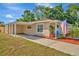 Tan house with carport, American flag, and palm tree at 6921 Onyx N Dr, St Petersburg, FL 33702