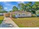 Tan house with carport, landscaped yard, and American flag at 6921 Onyx N Dr, St Petersburg, FL 33702