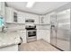 Modern kitchen with white cabinets, granite counters, and stainless steel appliances at 6921 Onyx N Dr, St Petersburg, FL 33702