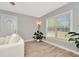 Bright living room features wood-look floors, large window, and comfy white couch at 6921 Onyx N Dr, St Petersburg, FL 33702