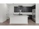 Modern kitchen island with white cabinets and dark countertops at 3778 Maxwell Park Dr, Sun City Center, FL 33573