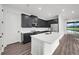 Modern kitchen with dark cabinetry, white countertops and stainless steel appliances at 3778 Maxwell Park Dr, Sun City Center, FL 33573