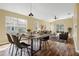 Bright dining room features a rustic table and chairs, hardwood floors, and access to the living area at 5723 Autumn Shire Dr, Zephyrhills, FL 33541
