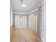 Walk-in closet with custom shelving, glass doors, and wood flooring at 5006 W San Miguel St, Tampa, FL 33629