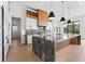 Elegant kitchen featuring a large island, marble countertops, sleek cabinetry, and stainless steel appliances at 5006 W San Miguel St, Tampa, FL 33629