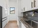 Modern kitchenette boasts granite counters, stainless steel sink, and white cabinets with black and gold pulls at 5006 W San Miguel St, Tampa, FL 33629