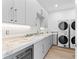 Bright laundry room featuring modern appliances, ample counter space, and custom cabinetry at 5006 W San Miguel St, Tampa, FL 33629