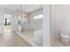 Bright bathroom features a glass-enclosed shower, soaking tub, toilet, and neutral tile flooring at 5006 W San Miguel St, Tampa, FL 33629