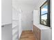 Walk-in closet with custom shelving and a window allowing for natural light and neighborhood views at 5006 W San Miguel St, Tampa, FL 33629