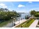Beautiful waterfront view showcasing a private dock and boat lift, with lush green surroundings at 5006 W San Miguel St, Tampa, FL 33629