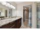 Bathroom featuring granite countertops, dark cabinets, and a sliding glass shower door at 8693 Bardmoor Blvd # 308B, Seminole, FL 33777