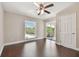 Bright bedroom with a ceiling fan, hardwood floors, and access to a private balcony at 8693 Bardmoor Blvd # 308B, Seminole, FL 33777