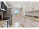 Well-lit kitchen with granite countertops, white cabinetry, and stainless steel appliances at 8693 Bardmoor Blvd # 308B, Seminole, FL 33777