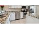 Eat-in kitchen with granite countertops, white cabinetry, and stainless steel dishwasher at 8693 Bardmoor Blvd # 308B, Seminole, FL 33777