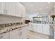 Beautiful kitchen with granite counters, white cabinets, and stainless steel sink at 8693 Bardmoor Blvd # 308B, Seminole, FL 33777