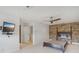 Spacious bedroom with hardwood floors, a ceiling fan, and a stone accent wall at 212 S Moody Ave # 2, Tampa, FL 33609