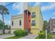 Modern three-story home with yellow and orange exterior and attached garage at 212 S Moody Ave # 2, Tampa, FL 33609