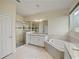 Elegant bathroom with soaking tub, walk-in shower, and granite countertops at 11818 Tetrafin Dr, Riverview, FL 33579