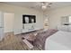 Bright bedroom featuring a large TV, wood-look floors and en-suite bathroom at 11818 Tetrafin Dr, Riverview, FL 33579