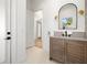 Bathroom with wood vanity, gray tile, and arched mirror at 3011 W Asbury Pl, Tampa, FL 33611