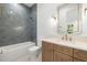 Elegant bathroom with blue tile, a bathtub, and a wooden vanity at 3011 W Asbury Pl, Tampa, FL 33611