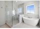 Spa-like bathroom with marble shower, soaking tub, and large window at 3011 W Asbury Pl, Tampa, FL 33611