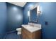 Elegant powder room with blue walls, hexagon tile, and gold fixtures at 3011 W Asbury Pl, Tampa, FL 33611