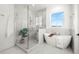 Luxurious bathroom with marble finishes, a soaking tub, and a walk-in shower at 3011 W Asbury Pl, Tampa, FL 33611