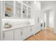 Bright butler's pantry with white cabinets, glass doors, and marble countertops at 3011 W Asbury Pl, Tampa, FL 33611