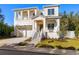 Two-story home with white exterior, gray roof, and a landscaped yard at 3011 W Asbury Pl, Tampa, FL 33611