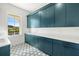 Laundry room with teal cabinets and geometric floor tiles at 3011 W Asbury Pl, Tampa, FL 33611