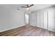 Bedroom with wood-look floors, ceiling fan, and built-in closet at 9527 Pebble Glen Ave, Tampa, FL 33647