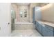 Elegant bathroom with a soaking tub, walk-in shower, and blue cabinets at 5034 Elm Leaf Dr, Brooksville, FL 34601