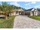 Two-story home with paver driveway and palm tree at 5034 Elm Leaf Dr, Brooksville, FL 34601