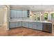 Modern kitchen featuring light blue cabinetry, marble countertops, and hardwood floors at 5034 Elm Leaf Dr, Brooksville, FL 34601