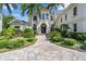Luxury home with arched windows, manicured landscaping, and a beautiful paved circular driveway at 19451 Ganton Ave, Bradenton, FL 34202