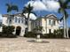 Stately cream-colored home featuring a beautiful brick circular driveway and a tranquil stone fountain at 19451 Ganton Ave, Bradenton, FL 34202