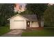 One story house with attached garage, landscaped yard, and a walkway to the front door at 7613 Piping Rock Ct, New Port Richey, FL 34654