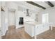 Modern white kitchen with large island, stainless steel appliances, and wood beams at 11618 Gleaming Ter, Venice, FL 34293