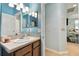 Bathroom with single vanity, light blue walls, and view to hallway at 6843 Boulder Run Loop, Wesley Chapel, FL 33545